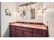 Bathroom vanity with a single sink, vanity lighting and a decorative mirror at 3544 Dyanna Dr, Thornton, CO 80241