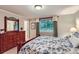 Charming bedroom with dresser, mirror, and a window view to the trees at 3544 Dyanna Dr, Thornton, CO 80241