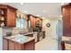 Well-lit kitchen with wood cabinets, tile countertops, and stainless steel appliances at 3544 Dyanna Dr, Thornton, CO 80241