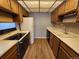Functional kitchen with wood cabinets, white appliances, and wood-look flooring at 14499 E 1St Dr # A05, Aurora, CO 80011