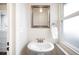Charming bathroom features a pedestal sink, modern fixtures, and a bright window at 2686 S Gilpin St, Denver, CO 80210