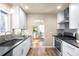 Open kitchen featuring white cabinets, a stainless steel sink, and view of dining room at 2686 S Gilpin St, Denver, CO 80210