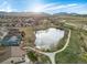 Aerial view of a community with a pond, walking paths, and mountain views at 12431 Red Fox Way, Broomfield, CO 80021