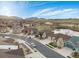 Aerial view of a neighborhood with houses, a pond, and rolling hills at 12431 Red Fox Way, Broomfield, CO 80021