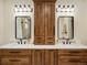 Luxurious bathroom offers a double sink vanity with wood cabinets, modern fixtures, and ample storage at 12431 Red Fox Way, Broomfield, CO 80021