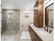 Elegant bathroom features a glass shower, double sink vanity, and luxurious marble countertops at 12431 Red Fox Way, Broomfield, CO 80021