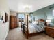 Cozy bedroom with a traditional four-poster bed, wood furniture, soft carpet, and natural light at 12431 Red Fox Way, Broomfield, CO 80021