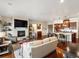 Spacious open-concept living area featuring a stone fireplace, kitchen island, and hardwood floors at 12431 Red Fox Way, Broomfield, CO 80021