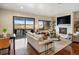 Open living room with a stone fireplace, sliding glass doors to a patio, and hardwood floors at 12431 Red Fox Way, Broomfield, CO 80021