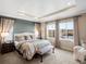 Tranquil bedroom with tray ceilings, soft natural light, and picturesque water views from the windows at 12431 Red Fox Way, Broomfield, CO 80021