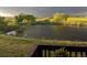 Picturesque pond surrounded by lush greenery with mature trees and open fields at 12431 Red Fox Way, Broomfield, CO 80021