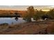 Scenic view features a serene pond reflecting the surrounding golden trees and peaceful landscape at 12431 Red Fox Way, Broomfield, CO 80021