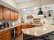 Stylish wet bar featuring granite countertops, wood cabinetry, and unique pendant lighting at 12431 Red Fox Way, Broomfield, CO 80021