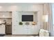 Modern living room and kitchen with sleek white built-ins, stainless steel appliances, and a wall-mounted TV at 2120 N Downing St # 216, Denver, CO 80205