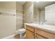 A cozy bathroom featuring a single sink vanity, bright mirror, and convenient wall shelves at 9816 W Freiburg Dr # A, Littleton, CO 80127