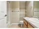 Cozy bathroom featuring single sink vanity, bright mirror, shower/bath and convenient wall shelves at 9816 W Freiburg Dr # A, Littleton, CO 80127
