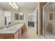 Bathroom with double sink, tiled shower, and connection to the bedroom at 9816 W Freiburg Dr # A, Littleton, CO 80127