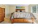 Bedroom view with neutral colors and decorative bed frame, matching nightstand and dresser, and mountain scene print at 9816 W Freiburg Dr # A, Littleton, CO 80127