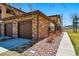 Exterior of a two-car garage featuring stone accents, brick and paved driveway at 9816 W Freiburg Dr # A, Littleton, CO 80127