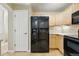 View of the kitchen showcasing a black stainless steel refrigerator with wood cabinets and tile backsplash at 9816 W Freiburg Dr # A, Littleton, CO 80127