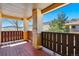 Covered porch view with wood flooring and tan-colored columns, offering views to the landscape at 9816 W Freiburg Dr # A, Littleton, CO 80127