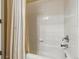 Bright shower featuring white wall tiles and a bathtub with white, decorative curtain at 9816 W Freiburg Dr # A, Littleton, CO 80127