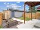 Backyard featuring a modern storage shed, a wood fence and flower boxes along a concrete walkway at 2226 S Galapago St, Denver, CO 80223