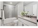 Modern bathroom featuring a shower-over-tub combination with gray and white tile and a vanity with quartz countertops at 2226 S Galapago St, Denver, CO 80223