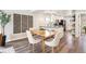 Bright dining room featuring a wood table, white chairs, modern lighting, and views into the kitchen at 2226 S Galapago St, Denver, CO 80223