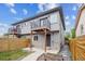 Two-story multifamily home with a gray exterior, a second-story balcony, and a fenced yard at 2226 S Galapago St, Denver, CO 80223