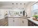 Modern kitchen island with quartz countertops, pendant lighting, stainless steel appliances, and views of the living space at 2226 S Galapago St, Denver, CO 80223
