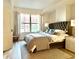 Bright main bedroom featuring a large window, king bed, elegant lamps, and natural light at 1975 N Grant # 310, Denver, CO 80203