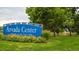 Well-maintained Arvada Center sign surrounded by colorful flowers and verdant landscaping at 8408 W 52Nd Ave, Arvada, CO 80002