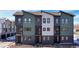 New construction townhome with modern design elements, including a combination of green, white, and gray siding at 8408 W 52Nd Ave, Arvada, CO 80002