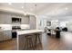 Open concept kitchen with stainless appliances, kitchen island, pendant lighting, and adjacent dining and living area at 8408 W 52Nd Ave, Arvada, CO 80002