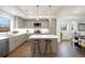 Modern kitchen with stainless steel appliances, quartz counters, center island with seating, and open to dining area at 8408 W 52Nd Ave, Arvada, CO 80002