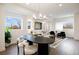 Spacious, open-concept living space is well-lit with an elegant chandelier and large windows overlooking the neighborhood at 8408 W 52Nd Ave, Arvada, CO 80002