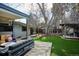 Expansive backyard with a deck, patio furniture, manicured lawn, and mature trees, perfect for outdoor living at 1423 S Eudora St, Denver, CO 80222