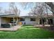 Expansive backyard showcasing a wooden deck with stylish furniture, a manicured lawn, and mature trees at 1423 S Eudora St, Denver, CO 80222