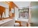 Bathroom features wood paneling, soaking tub by a window, and stylish fixtures at 1423 S Eudora St, Denver, CO 80222