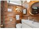 Stylish bathroom features wood-paneled walls, modern sink and a round mirror at 1423 S Eudora St, Denver, CO 80222