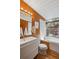 Bright bathroom featuring wood paneling, a tub with a garden window, and a sleek white vanity at 1423 S Eudora St, Denver, CO 80222