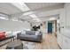 Bright living room with hardwood floors, skylights, a gray sofa, and a view of the backyard at 1423 S Eudora St, Denver, CO 80222