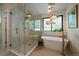 Bright bathroom with a walk-in shower and freestanding tub with modern fixtures and unique lighting at 10701 Flagler Dr, Parker, CO 80134
