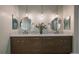 Bright bathroom featuring a double vanity with modern lighting, mirrors, and fixtures at 10701 Flagler Dr, Parker, CO 80134