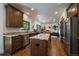 A well-appointed kitchen features stainless appliances, custom cabinetry, granite counters, a center island, and hardwood floors at 10701 Flagler Dr, Parker, CO 80134