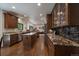 A well-appointed kitchen features stainless appliances, custom cabinetry, granite counters, a center island, and hardwood floors at 10701 Flagler Dr, Parker, CO 80134