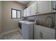 Functional laundry room with modern washer and dryer, stylish flooring, and plenty of storage at 10701 Flagler Dr, Parker, CO 80134