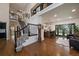 Inviting living room and staircase featuring wood floors, a decorative grandfather clock, and elegant wrought iron railings at 10701 Flagler Dr, Parker, CO 80134