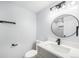 Bright bathroom featuring a modern vanity, round mirror and sleek black fixtures at 2203 S Holly St # 3, Denver, CO 80222